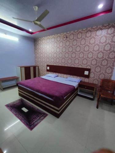 AnūppurHOTEL KANHA INTERNATIONAL, Anuppur的一间卧室配有一张大床和紫色毯子