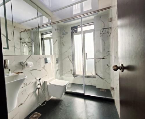 孟买Premium Apartment in Hiranandani Powai by Maxxvalue - Chitranjan的浴室配有卫生间、盥洗盆和淋浴。