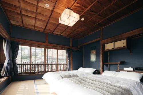 壹岐市LAMP Iki的配有两张床铺的蓝色墙壁和窗户
