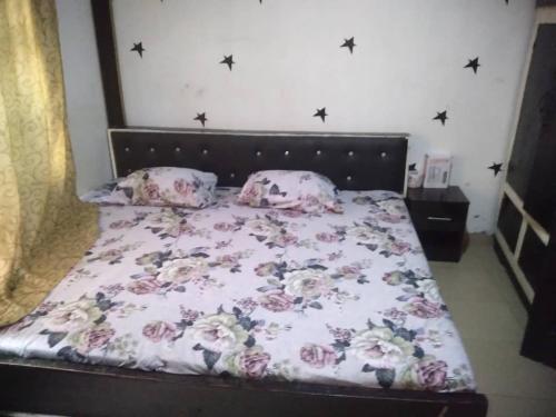 伊巴丹Two bedroom Home at Gbagi, New Ife Road, Ibadan @ Igbekele Oluwa House, 3 Zone A, Opeyemi Street, New Gbagi Market, New Ife Road, Gbagi, Ibadan, Oyo State的一间卧室配有一张带花卉床罩和枕头的床