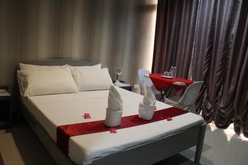 GateLORELEI BEACH RESORT的酒店客房配有一张床铺和一张带红色毯子的桌子。