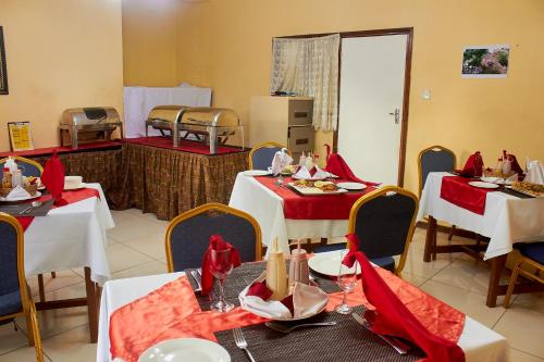 ZombaMango Lodge Zomba的用餐室配有桌椅和红色餐巾