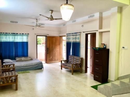 Pirojpur Guest House的一间卧室,卧室内配有一张床和一把椅子