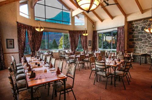 温特顿Cathedral Peak Hotel的用餐室设有桌椅和窗户。