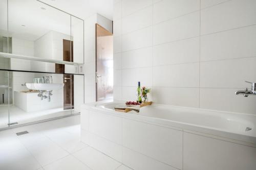 迪拜Frank Porter - Index Tower的白色的浴室设有浴缸和水槽。