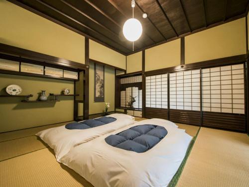 Toon瀧乃元 近藤家（Kondoke-Inn)的一间卧室配有一张带蓝色枕头的大床