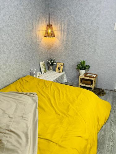 Plei KêpKen House 1993的一张床上,床上有黄色的毯子,放在房间里