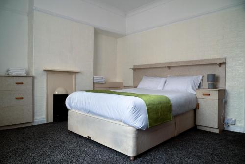 普雷斯顿Amarillys Guest House的一间卧室配有一张带绿毯的大床