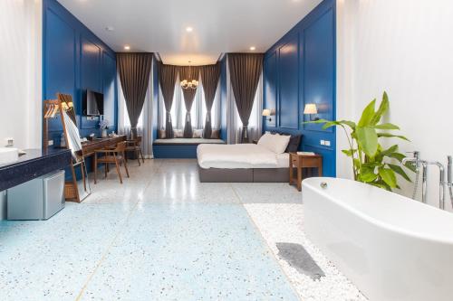 普吉镇The Elements Boutique House的拥有蓝色墙壁的浴室、一张床和一个浴缸