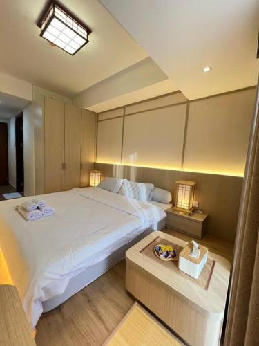 KangboiWawa Guesthouse Pollux Habibie Batam Tower A 17的卧室配有一张白色的大床和一张桌子