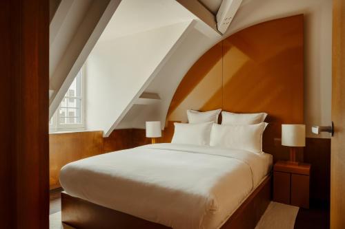 巴黎Edgar Suites - Bouchardon的卧室设有一张白色大床和楼梯