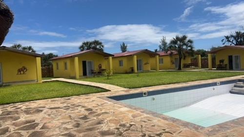 乌昆达Coral Villas Cottage的连排的黄色房子,带有游泳池
