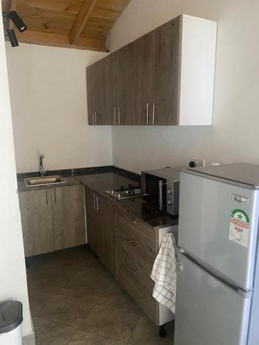 乌昆达Coral Villas Cottage的厨房配有白色冰箱和木制橱柜。