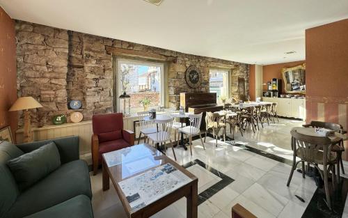 雷诺萨波萨达维拉罗萨酒店的客厅设有桌椅和石墙