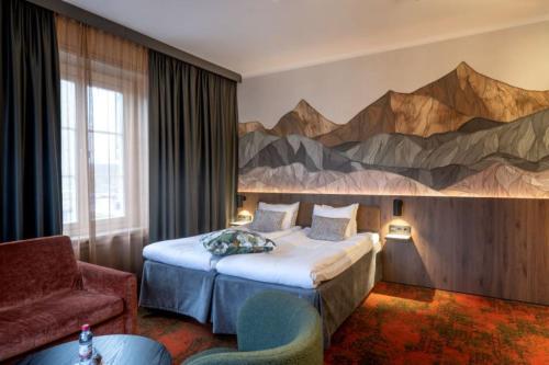 法伦克拉丽奥堡马斯塔伦连锁酒店的酒店客房设有一张床,墙上挂有绘画作品