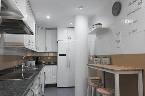 塞维利亚MonKeys Apartments Lumbreras Deluxe的厨房配有白色橱柜和白色冰箱。