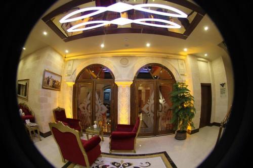 马尔丁Tuğhan Hotel的一间带红色椅子和天花板的客厅