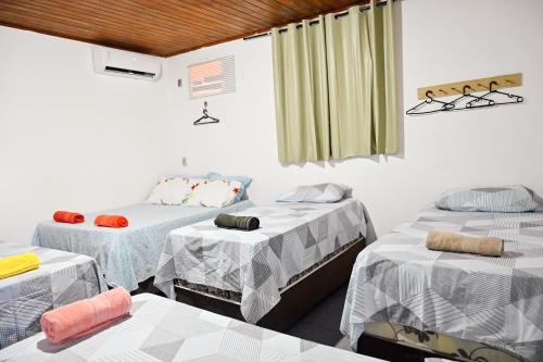 阿拉卡茹Hostel mineiros的带三张床和窗户的客房