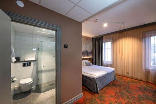 法伦克拉丽奥堡马斯塔伦连锁酒店的一间卧室设有一张床、淋浴和卫生间