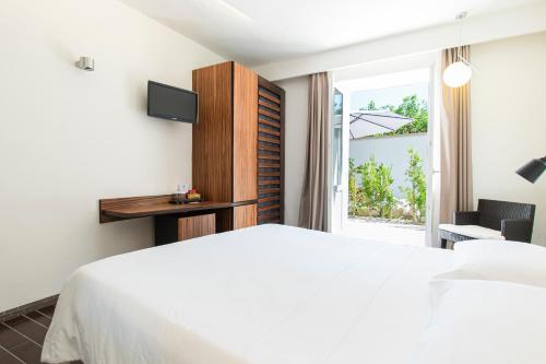 伊斯基亚玛莉娜10精品设计酒店的卧室配有白色的床和窗户。