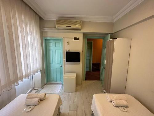 库萨达斯Hikmethan Otel的小房间设有两张床和电视
