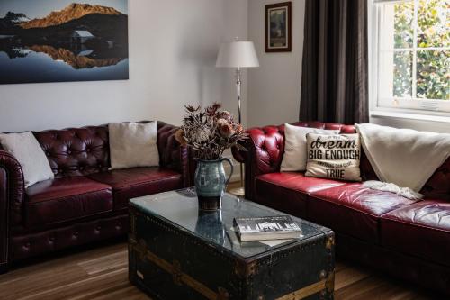 霍巴特圣殿精品公寓的客厅设有两张沙发和一张带鲜花的桌子