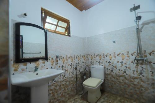 锡吉里亚The Green Heaven Resort的一间带水槽、卫生间和镜子的浴室