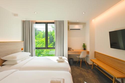 曼谷ZEN MASTER HOTEL的酒店客房配有一张床、一张书桌和一台电视。