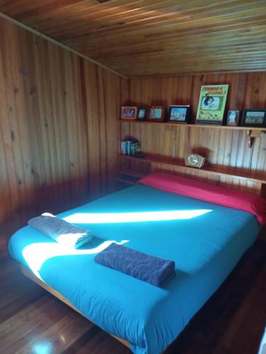 坎加斯德穆拉索Casa de Madera的木制客房内的一张床位,上面有两个枕头