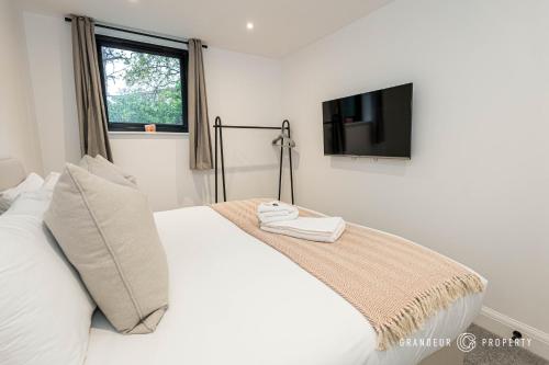 ParkstoneNEW Elegant apartment, 2 bed, balcony, Poole - Aurora's Abode的卧室配有一张床铺,墙上配有电视