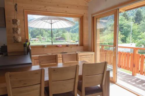 里雾诗Le Lac - Servoz - Appartement paisible de 70m²的一间带桌椅和大窗户的用餐室