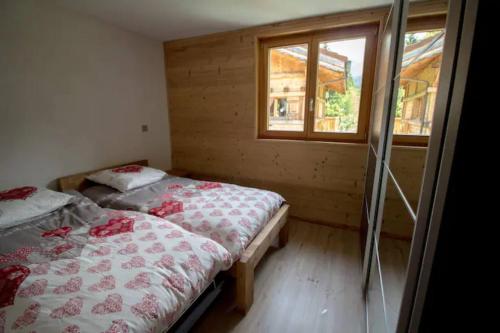 里雾诗Le Lac - Servoz - Appartement paisible de 70m²的小型客房 - 带2张床和窗户