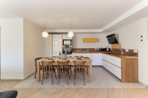 里雾诗L'Abeille - Renovated - 4 bedroom - 8 person-110sqm - Views!的一间厨房,内设一张木桌和椅子