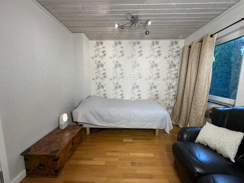 泰比Stockholm-Arlanda privat rum i rymlig villa gratis wifi 1Gb fiber parkering Room1的小房间设有床和沙发