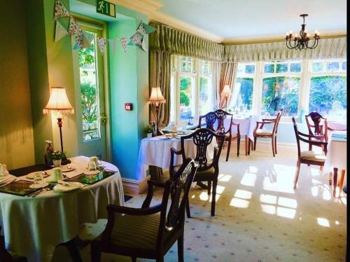 鲍内斯温德米尔斯托尔斯大门别墅酒店的用餐室设有桌椅和窗户。