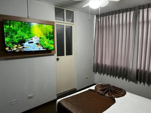 伊洛Costa Bella的卧室设有壁挂式电视和床。