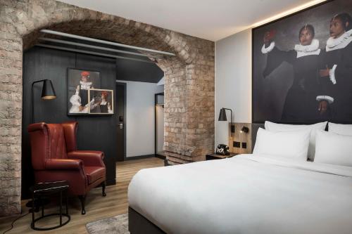 利物浦Radisson RED Hotel, Liverpool的配有一张床和一把椅子的酒店客房