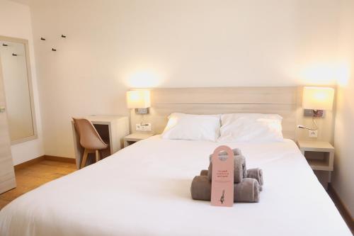 里尔HOTEL AMBASSADEUR的一间卧室,配有一张带两个泰迪熊的床