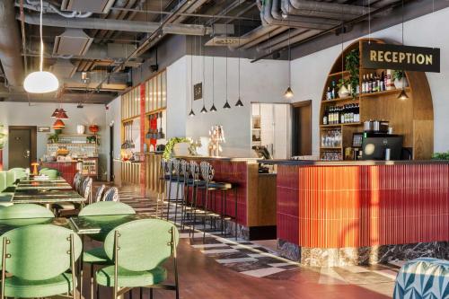 斯德哥尔摩Best Western Plus Hotel Kungens Kurva的一间设有绿色椅子的餐厅和一间酒吧