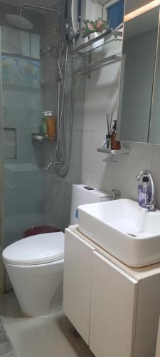马尼拉Mariz Cozy and Elegant room的一间带水槽、卫生间和镜子的浴室