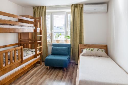 特尔纳瓦Sunny apartment in Trnava的一间卧室配有两张双层床和一张蓝色椅子