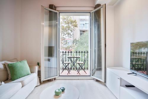 巴塞罗那BcnStop Sant Pau Suites的带沙发和大窗户的客厅