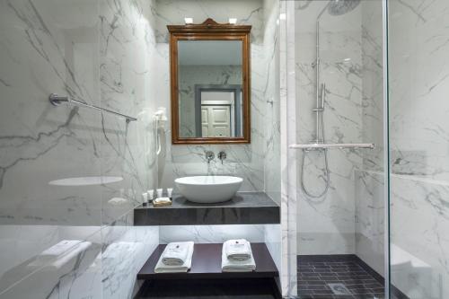 伊兹拉伊兹拉希德劳萨旅馆的一间带水槽和玻璃淋浴的浴室