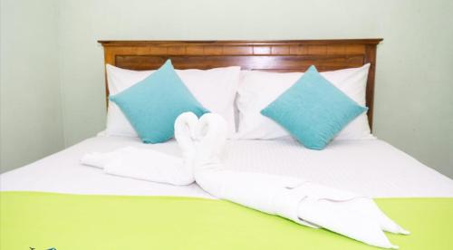 卡图纳耶克Airport Villa D 87的一张带两个白色棉床单和两个蓝色枕头的床