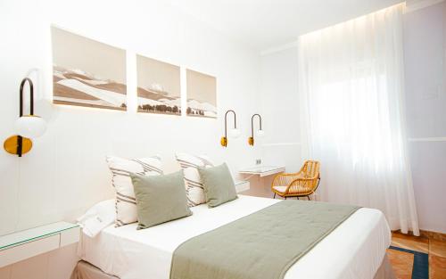科尔多瓦绿洲酒店的白色卧室配有床和桌子