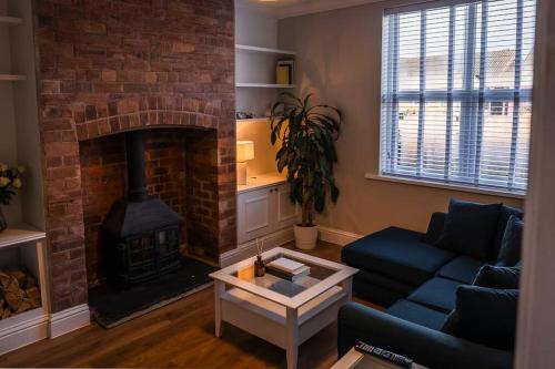 利Renovated 3 Bedroom House in Lowton Pennington的客厅设有壁炉和蓝色沙发。