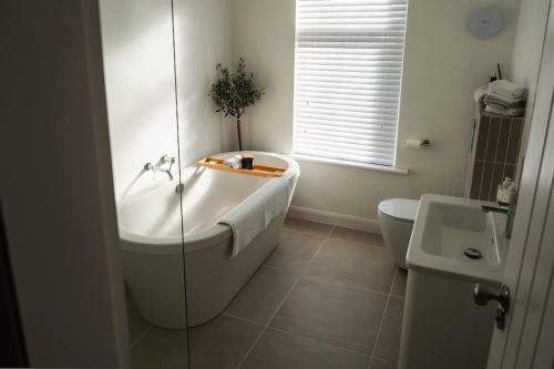利Renovated 3 Bedroom House in Lowton Pennington的带浴缸、卫生间和盥洗盆的浴室