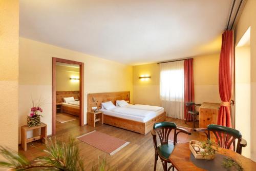 蒂罗尔-泽费尔德Alpenhof的酒店客房配有一张床和一张餐桌。