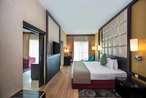 迪拜阿尔巴沙俊宏酒店的酒店客房,配有床和电视