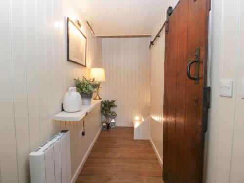 珀肖尔The Annex的走廊设有一扇门,通往一间铺有木地板的客房